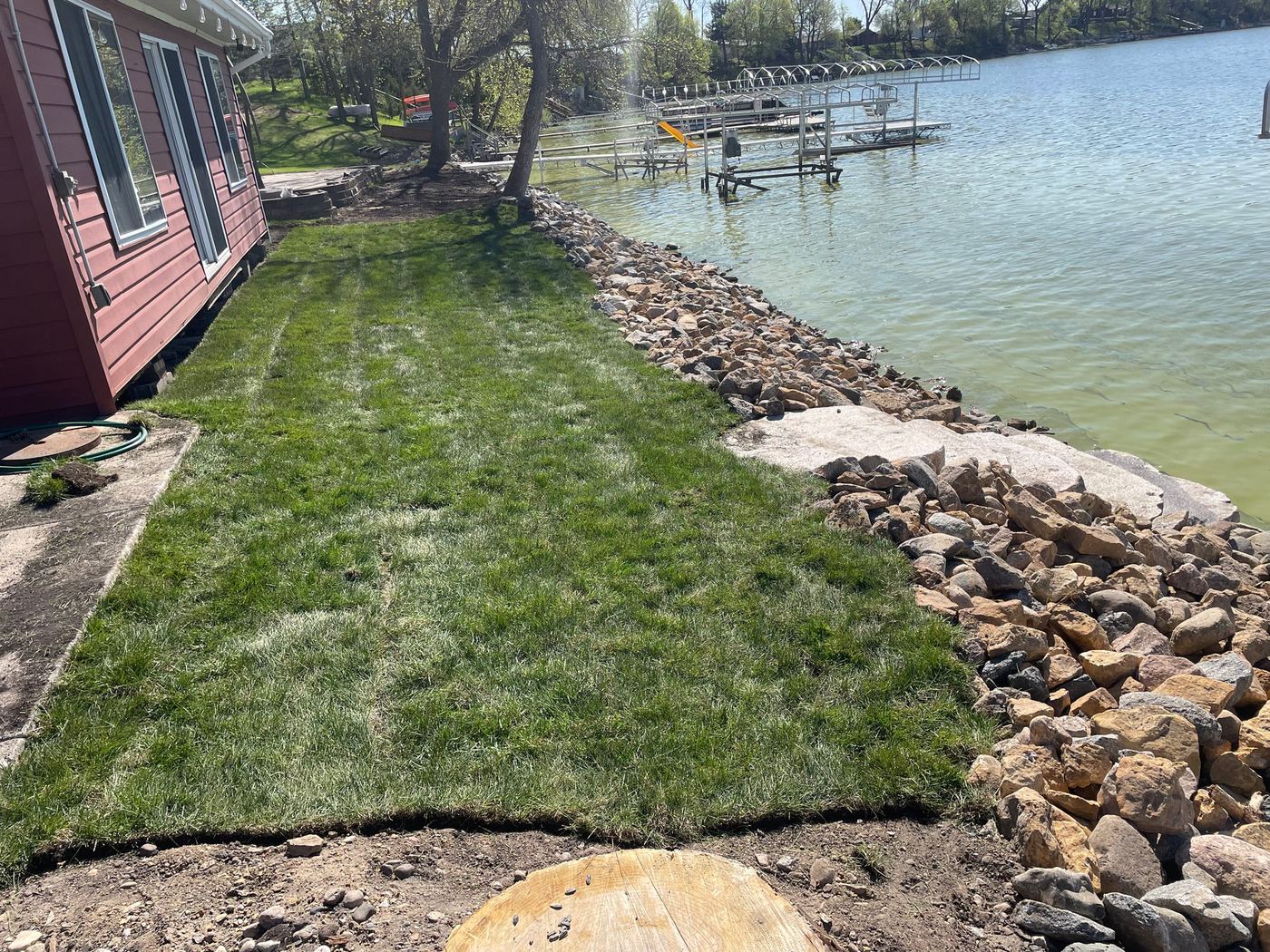 Rebuilt rock shoreline with fresh sod along a lake