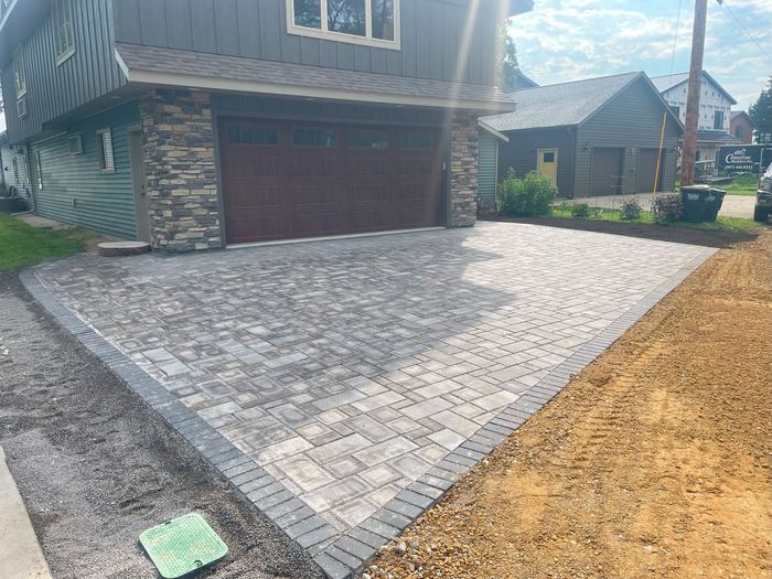 Gray paver driveway apron in front of a garage